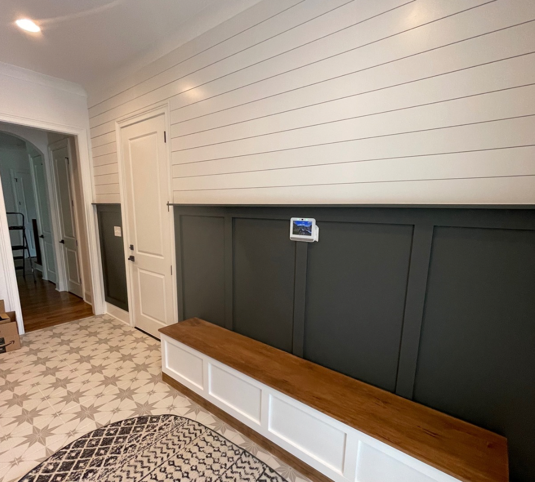 Eingangsbereich mit maßgefertigter Sitzbank und Wandverkleidung in Dunkelgrün