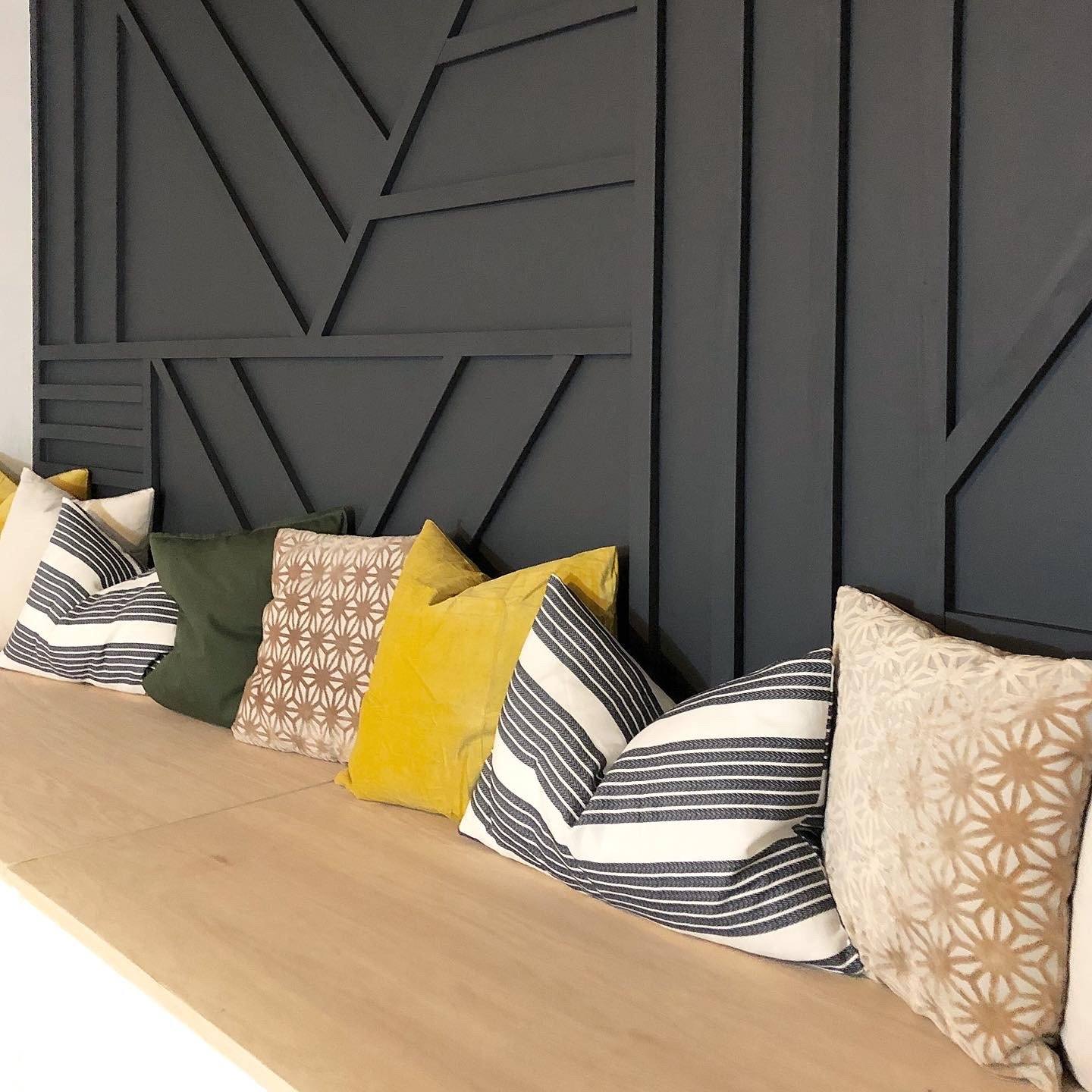 Wohnbereich mit dekorativer schwarzer Wandverkleidung und gemütlicher Sitzecke