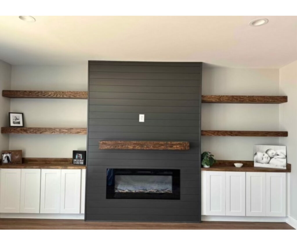 Elektrischer Kamin mit Wandverkleidung aus Holzlamellen, schwebenden Regalen und Einbauschränken – gebaut von Majetic Raum & Ausbau in Seeheim-Jugenheim