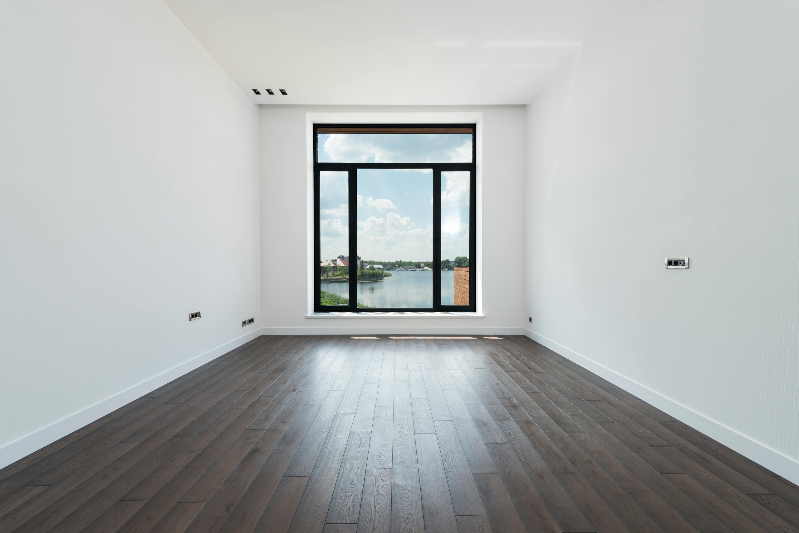 Dunkles Laminat in modernem Wohnzimmer mit großem Fenster in Seeheim